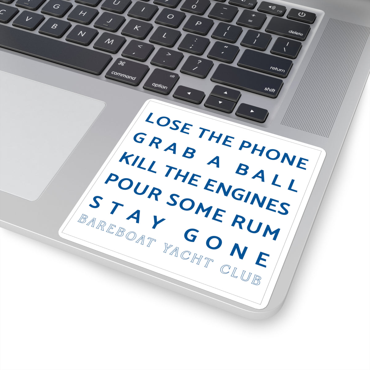 White motto sticker on a laptop: Lose the phone. Grab a ball. Kill the engines. Pour some rum. Stay gone.