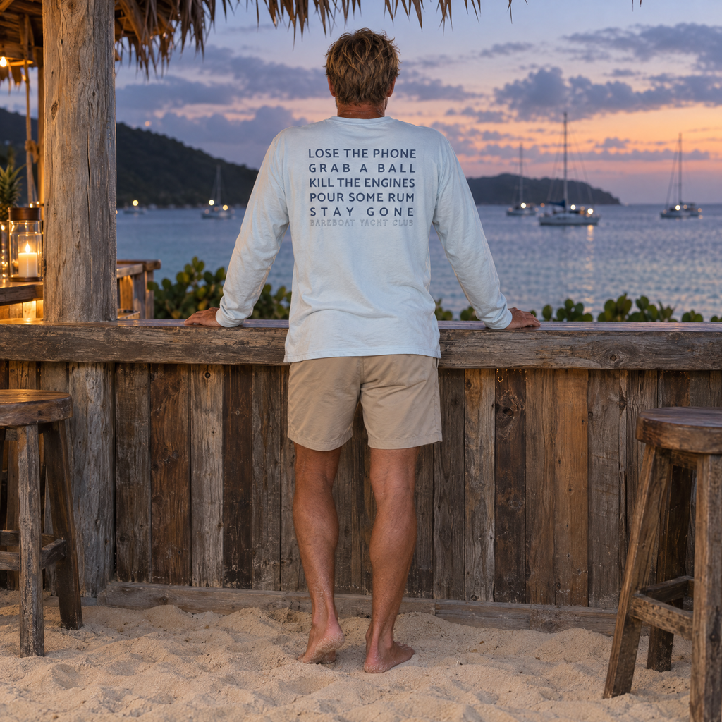 The chambray Bareboat Motto Long Sleeve worn, back view: Lose the phone. Grab a ball. Kill the engines. Pour some rum. Stay gone.