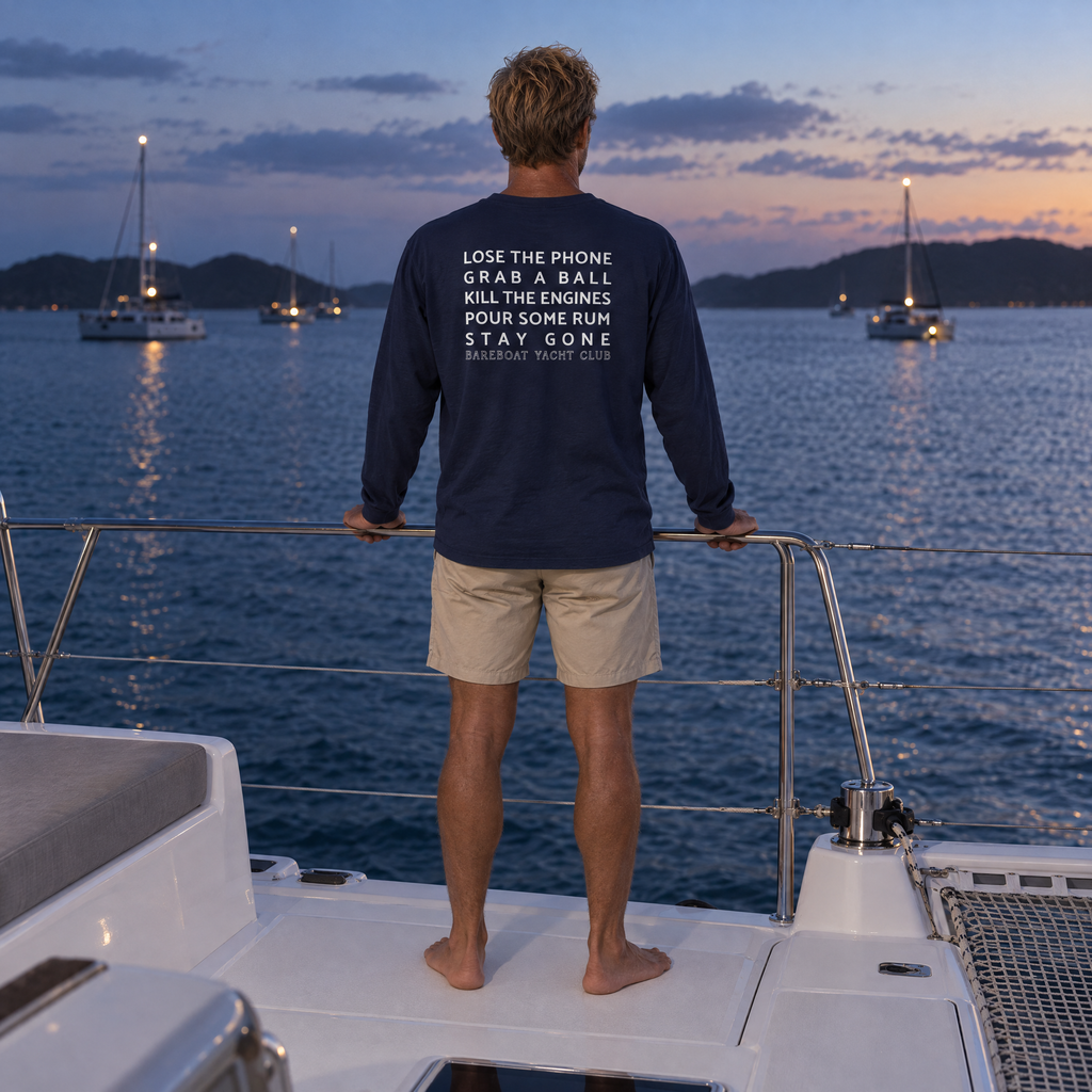 The navy Bareboat Motto Long Sleeve worn, back view: Lose the phone. Grab a ball. Kill the engines. Pour some rum. Stay gone.